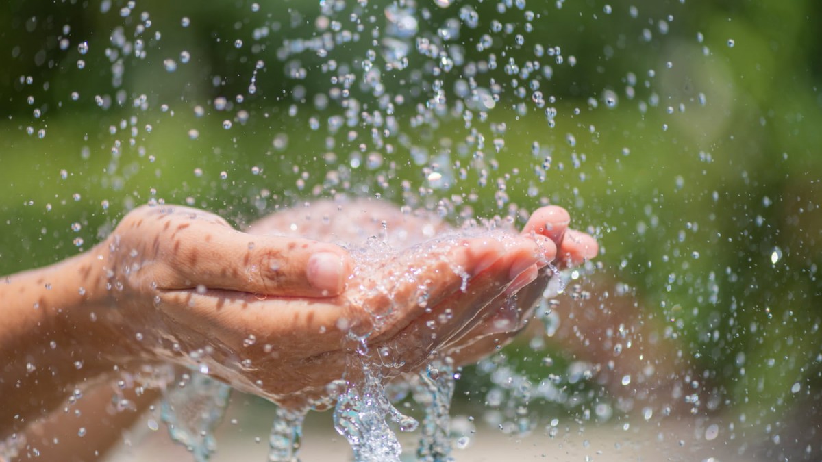 Água caindo na mão de uma pessoa, simbolizando o tanino no tratamento de água e efluentes.